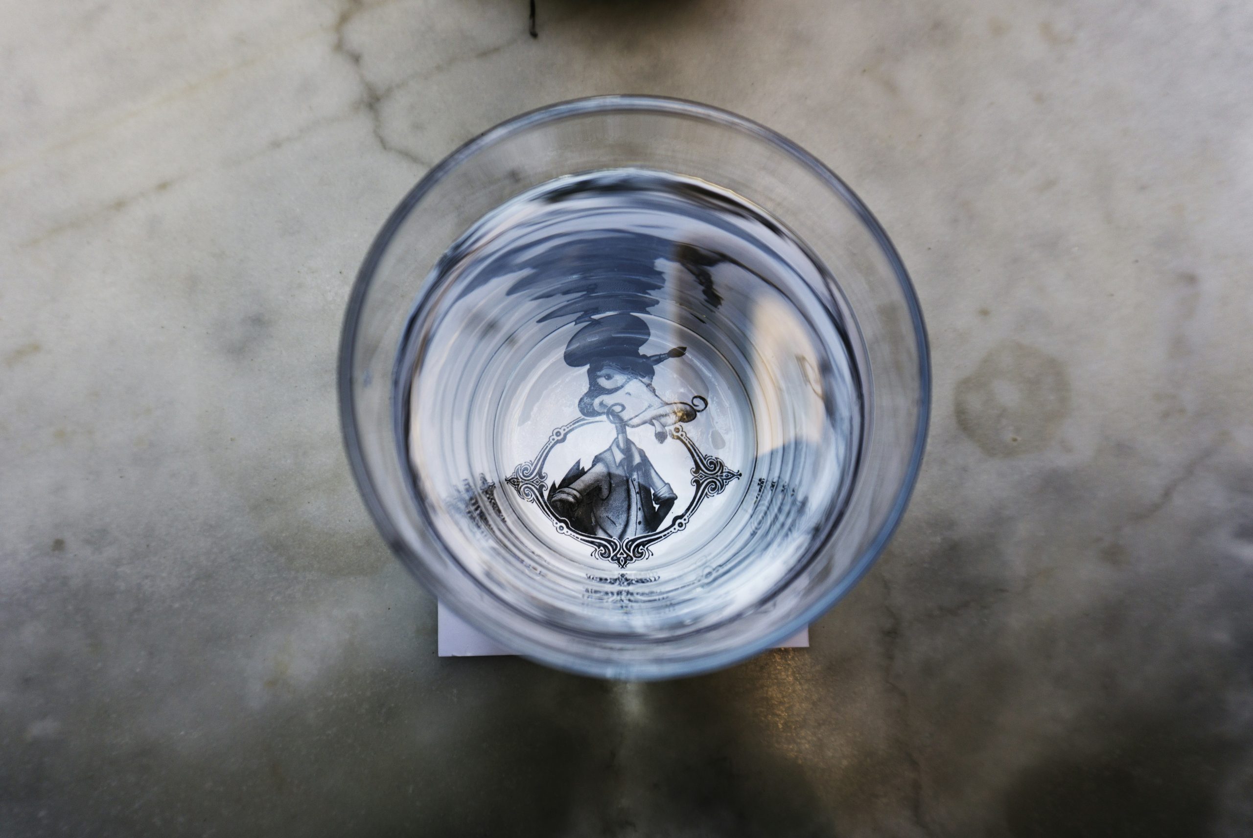 glass of clear water resting on a marble surface, highlighting the purity and clarity that Brita Pro filtration delivers for healthier hydration