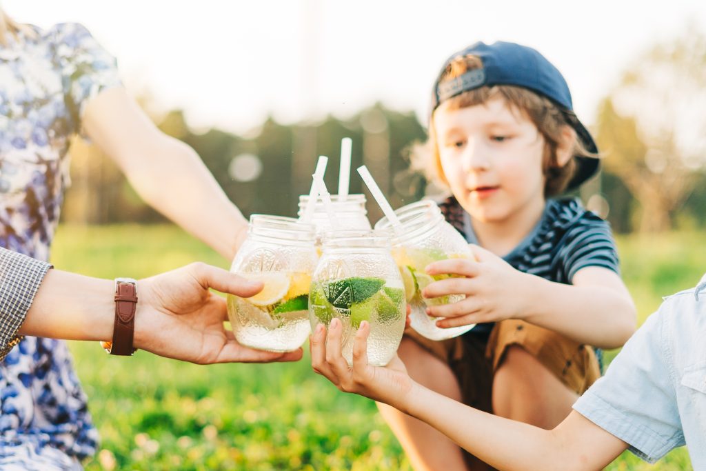 Family enjoying refreshing lemon water outdoors, highlighting Brita Pro filtered water for healthy hydration during summer picnics.