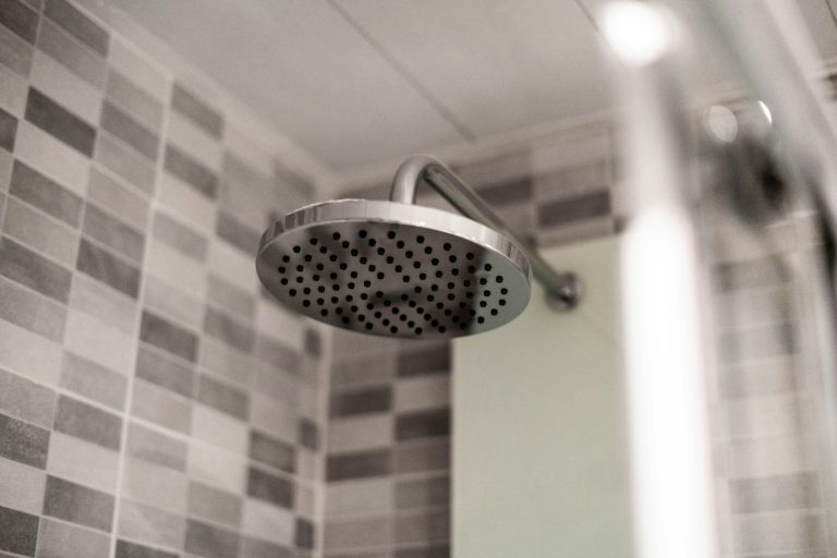 Stainless steel shower head in a tiled bathroom